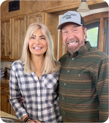 Chuck Norris and female standing in kitchen.